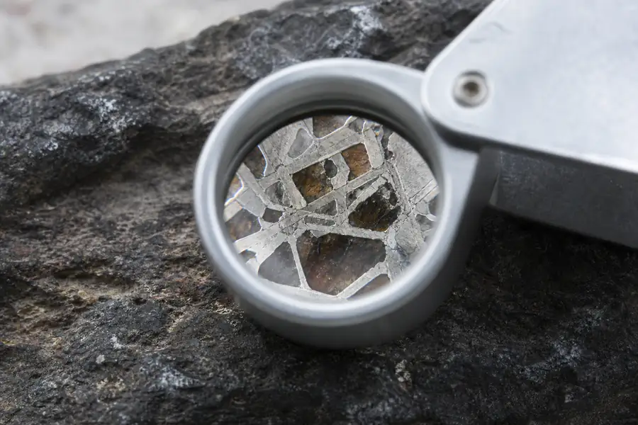 A jeweller's loupe over a meteorite inlay