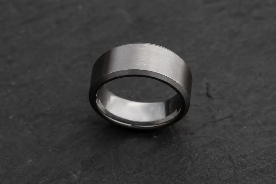 A tungsten ring photographed against a dark textured background