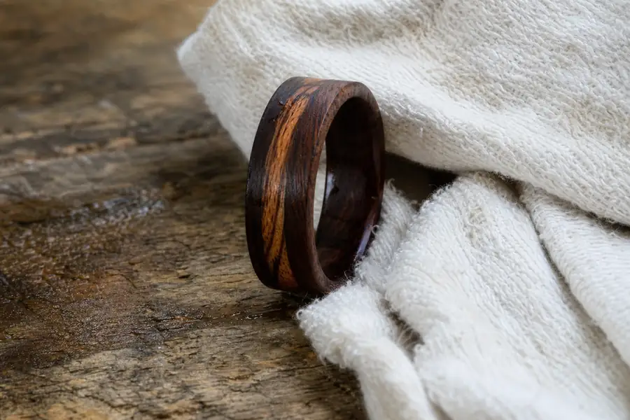 A wood inlay band being dried with a soft cloth